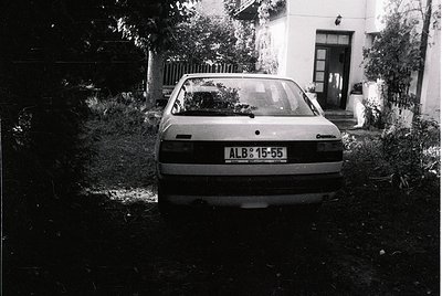 A vintage **Volkswagen Passat** (ALB 15-55) parked on overgrown grass beside a residential building, likely Eastern Bloc-era....