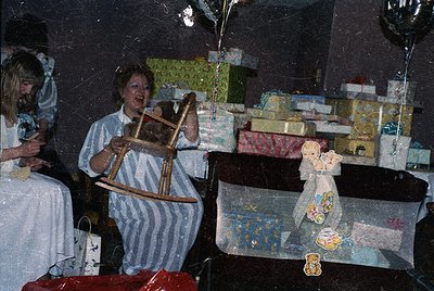 Vintage holiday scene featuring a woman in a striped apron holding a wooden rocking horse. Surrounding her are wrapped gifts,...