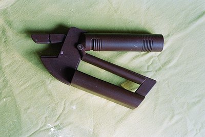 Vintage-style bolt cutter with dark brown, textured grip and forged metal jaws, resting on green fabric. Classic design for h...