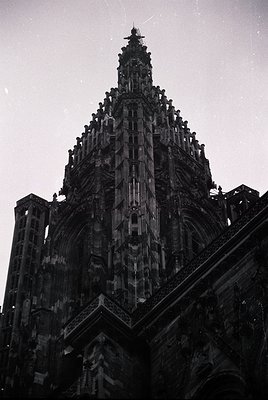 Gothic spire with intricate tracery and pinnacles, likely part of a European cathedral. Stonework features vertical buttresse...