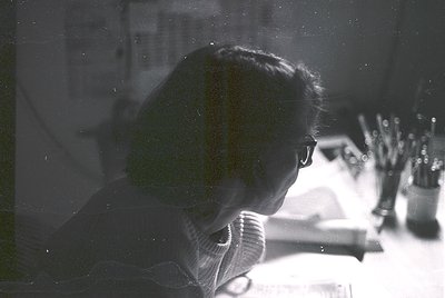 Silhouetted figure in mid-conversation on a vintage telephone, blurred vintage filter. Indoor setting with blurred floral arr...