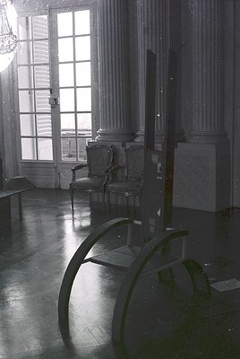 Neoclassical interior featuring grand double doors with frosted glass panes, flanked by fluted Corinthian columns. A vintage ...