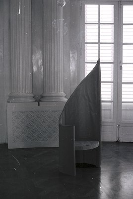 Neoclassical interior featuring two fluted Corinthian columns with decorative capitals flanking a marble fireplace. A draped ...