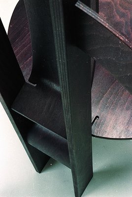 Mid-century modern wooden chair with angular, geometric design—dark-stained wood frame and seat. Clean lines, minimalist aest...