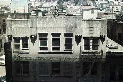Three-story brick commercial building façade, likely early 20th century. Symmetrical design with decorative cornice and fire ...