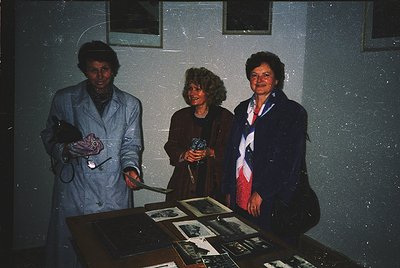 Three women pose indoors, likely in a medical or institutional setting from the 1970s–1980s. Left: nurse in white lab coat ho...
