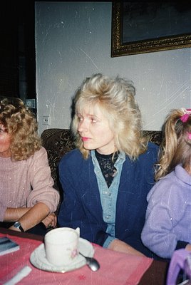 Vintage indoor portrait of three women in 1970s-era clothing: voluminous hairdos, patterned cardigans, and floral/neutral blo...