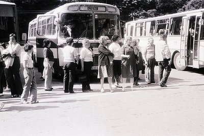 Crowd boarding a vintage **Zajazd** branded bus, likely Eastern European, mid-20th century. People in casual 1960s–70s attire...