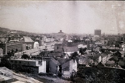 Early 20th-century urban panorama featuring dense, low-rise buildings with flat roofs and minimalist architecture. Prominent ...