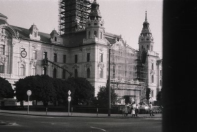 Historic European building under restoration, featuring intricate Baroque-style facades and scaffolding. Prominent twin tower...