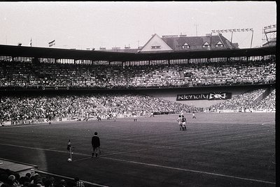 Vintage black-and-white stadium shot showing packed stands with dense crowd, likely 1960s-70s. Prominent "Krenov" advertiseme...