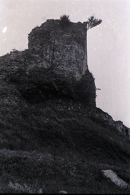Medieval stone watchtower perched atop rugged cliff face, showcasing weathered masonry and sparse vegetation. Likely Eastern ...