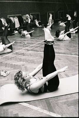 Vintage black-and-white photo of ballet dancers practicing in a studio, mid-20th century. Central figure in a split pose on a...