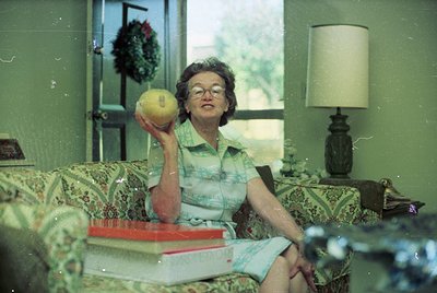 Mid-century living room interior featuring a woman in a striped blouse and light-colored skirt, holding a tennis ball. Floral...