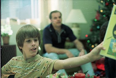 Vintage indoor scene featuring a boy in a striped shirt playing with a handheld game (likely *Pong* or similar arcade console...
