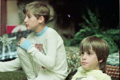 Vintage indoor portrait of two boys in matching long-sleeve sweatshirts, likely 1980s-1990s. One holds a mug, both pose near ...