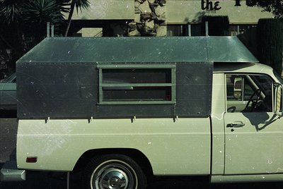 Vintage delivery van with boxy, utilitarian design—distinctive flat roof, rear sliding window, and minimalist exterior. Likel...