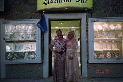 Two women pose outside a vintage silverware shop, "Zlatna Pani," in Bulgaria. The 1970s-era storefront features glass display...