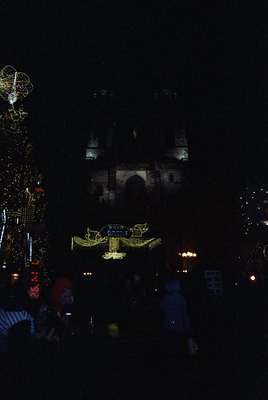 Nighttime festive display featuring illuminated architectural projections on a historic building, likely a mosque. Decorative...