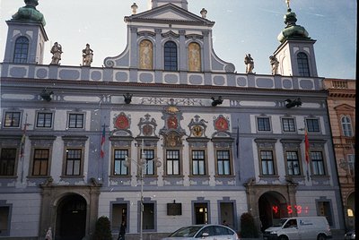 Baroque-style building with ornate façade featuring sculpted figures, heraldic crests, and decorative reliefs. Symmetrical de...