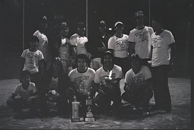 Vintage black-and-white photo of a youth football team posing with a trophy on a dirt field. Uniforms feature "YFC" logos and...