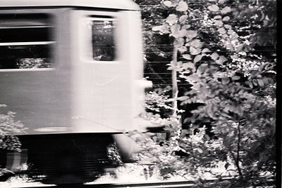 Mid-20th century passenger train in motion, blurred motion emphasizing speed. Classic streamlined design with rounded edges a...