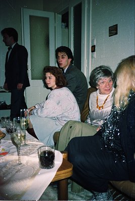 1970s indoor gathering at a formal event, likely a wedding or banquet. Three women in layered clothing (one in a white coat, ...