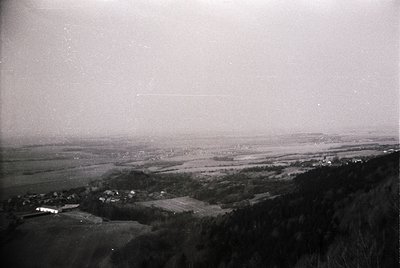 Vintage aerial view of a rural landscape with scattered farmhouses and fields, likely mid-20th century. Low-lying hills and d...