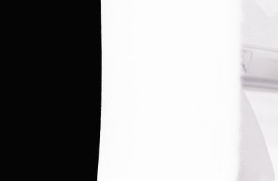Abstract photographic study showcasing a stark contrast. Dominant white space transitions abruptly to a black band on the lef...