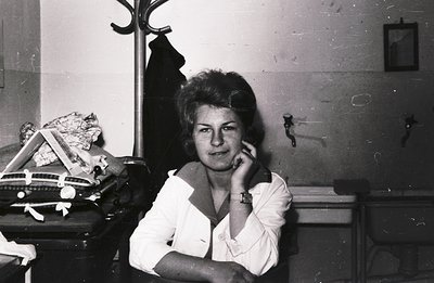 A young woman in a crisp, button-down shirt poses thoughtfully. She rests her chin on her hand, exhibiting a contemplative ex...