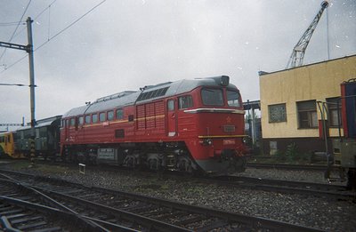 A red, Soviet-era diesel locomotive (likely a TE1 series) sits on tracks within a railway depot. The number 17630 is visible ...