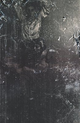 A heavily distressed black and white photograph depicts a figure in dark clothing, seemingly caught mid-motion, possibly danc...