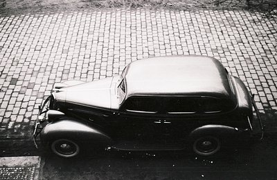 High-angle view of a classic 1937-1939 LaSalle sedan, showcasing its streamlined Art Deco design. Parked on a cobblestone str...
