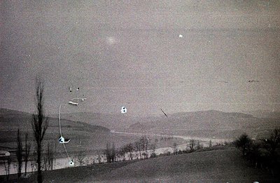 Striking aerial view captures skiers navigating a snow-covered landscape with distant, hazy mountains. Likely a promotional i...