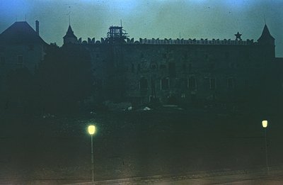 Striking low-angle view of a monumental, austere building featuring a central tower topped with a star. Likely a government o...