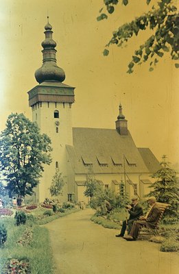 Charming vintage color photograph of a church with a distinctive onion dome, likely Eastern European architecture. A gravel p...