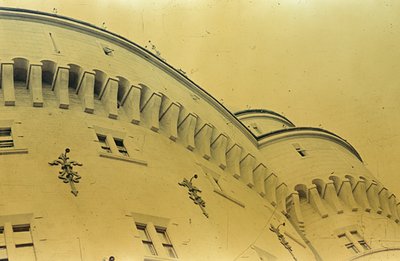 Detailed view of an ornate building façade with arched windows and decorative balustrades. Likely early 20th century architec...