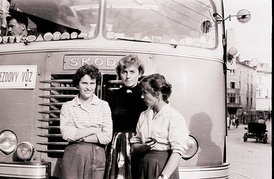 Three people pose by a Škoda bus, likely in Czechoslovakia (now Czech Republic). The bus displays "PŘEZDOVY VŮZ" signage. Two...