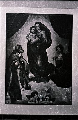 Seated Virgin Mary cradling a child, flanked by a bearded man and a woman, with cherubic figures floating nearby on clouds. L...