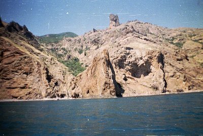 Striking sandstone cliffs rise dramatically from the dark blue sea. This appears to be the Albena cliffs near Varna, Bulgaria...