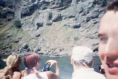 A close-up perspective captures three individuals on a boat tour, framed by the photographer's face. A woman with blonde hair...