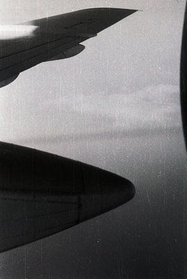 Striking black and white photo depicts a building's sharp, triangular form casting a dramatic shadow across a textured surfac...