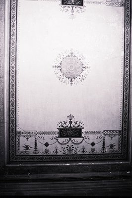 Decorative wall panel features ornate borders and symmetrical floral motifs, likely from an interior design element. The cent...