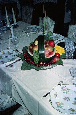 Elaborate centerpiece features a carved watermelon, displaying fruits like cherries, grapes, and apples on a bed of greenery....