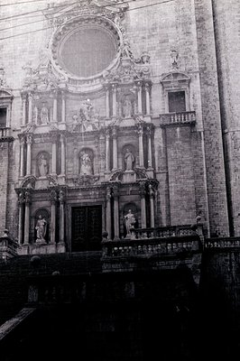 Ornate facade of a baroque-style building featuring sculptural relief, statues, and arched doorways. Monumental scale with a ...