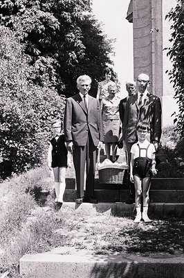 Formal portrait, likely 1960s. Family ascends stone steps; father and son in suits, mother & daughter in patterned dress & pi...