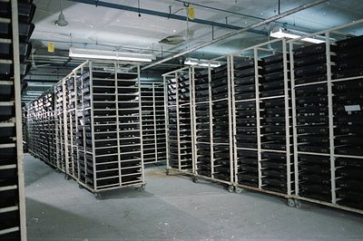 High-density archival storage system with numerous labeled film canisters. Likely a film archive or library, demonstrating or...