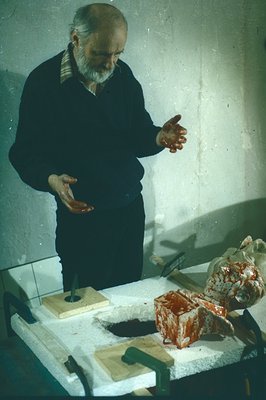 A man with a beard gestures as he observes a laboratory setup. The table holds a dissected specimen (likely anatomical), tool...