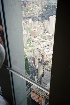 High-angle cityscape view from an elevated position, likely an observation deck or skyscraper. Dense urban architecture domin...
