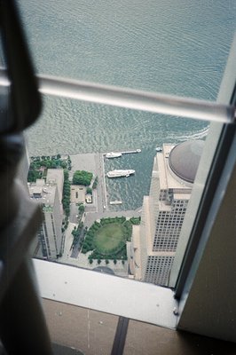 High-angle view through a window reveals a harbor scene featuring a modern building with a domed roof, likely a convention ce...